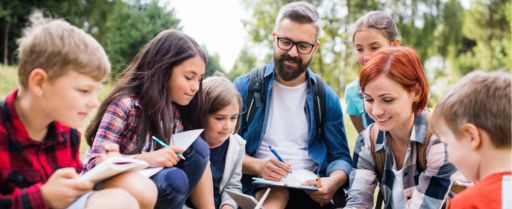 children smile and take notes while sitting in a circle